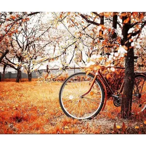 Canvastavla 70x100 cm - Cykel lutad mot ett träd i en höstig landskap med orangea och gula löv Orange / Gul / Brun - Inredning Bästa pris