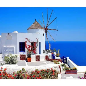 Nyhet Canvastavla 70x100 cm - Pittoresk vy av en vitkalkad byggnad med en traditionell vindmölla och färgglada blommor i Santorini Vit / Blå / Röd - Inredning