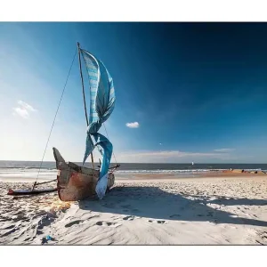 Köp nu Canvastavla 70x100 cm - Segelbåt med blå segel på en strand Blå / Beige / Brun - Inredning