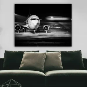 Canvastavla 70x100 cm - Svartvit bild av ett flygplan på en flygplats under natten Svart / Vitt / Grått - Inredning Sista chansen
