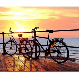 Billig Canvastavla 70x100 cm - Två cyklar som står på en brygga vid solnedgången över havet Orange / Svart / Gult - Inredning
