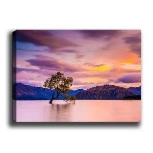 Canvastavla 70x100 cm - Ensam trädstam i en spegelblanka sjö med fjärran berg i bakgrunden under en färgsprakande himmel vid solnedgången Lila / Grön / Orange - Inredning Nyhet